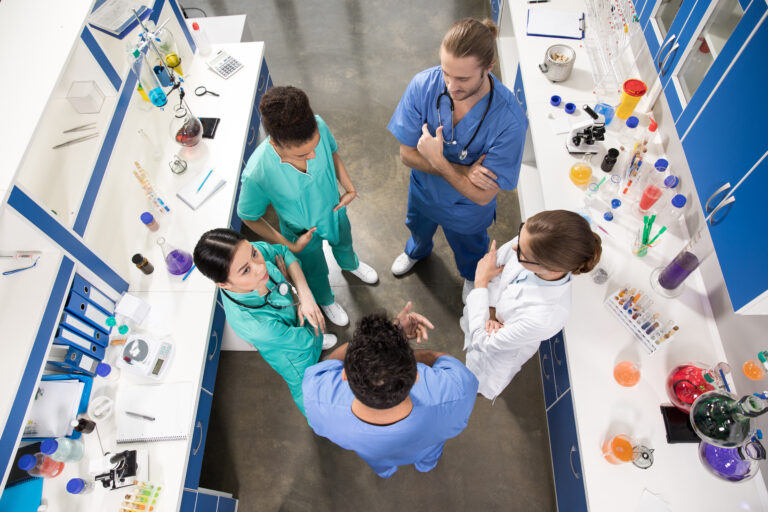 high angle view of colleagues discussing work in laboratory