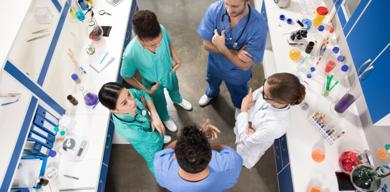 high angle view of colleagues discussing work in laboratory